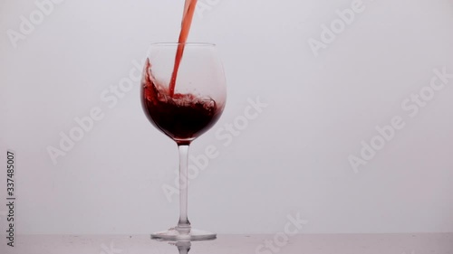 pours wine into a glass in slow motion