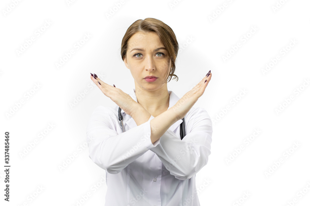 Close up beautiful young female doctor in white medical coat and stethoscope doing sign of prohibition with serious and confident expression, defense gesture, isolated white background, taboo concept Close up beautiful young female doctor in white medical coat and stethoscope doing sign of prohibition with serious and confident expression, defense gesture, isolated white background, taboo concept