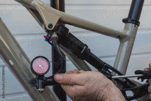 Tableau sur toile Pumping the rear shock or absorber of a modern mountain bicycle using a hand pressure pump