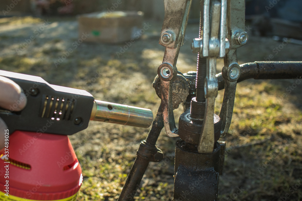 Heating a siezed metal rod on a splined rod or axle, using a three jaw spanner and a propane heater to release the tension and separate two metal objects. Heating a siezed metal rod on a splined rod or axle, using a three jaw spanner and a propane heater to release the tension and separate two metal objects.