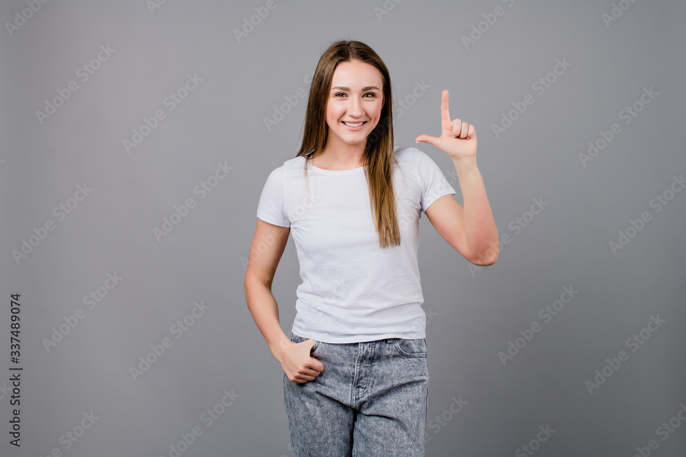 woman showing two fingers isolated on grey background woman showing two fingers isolated on grey background