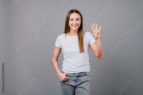 woman showing four fingers isolated on grey background