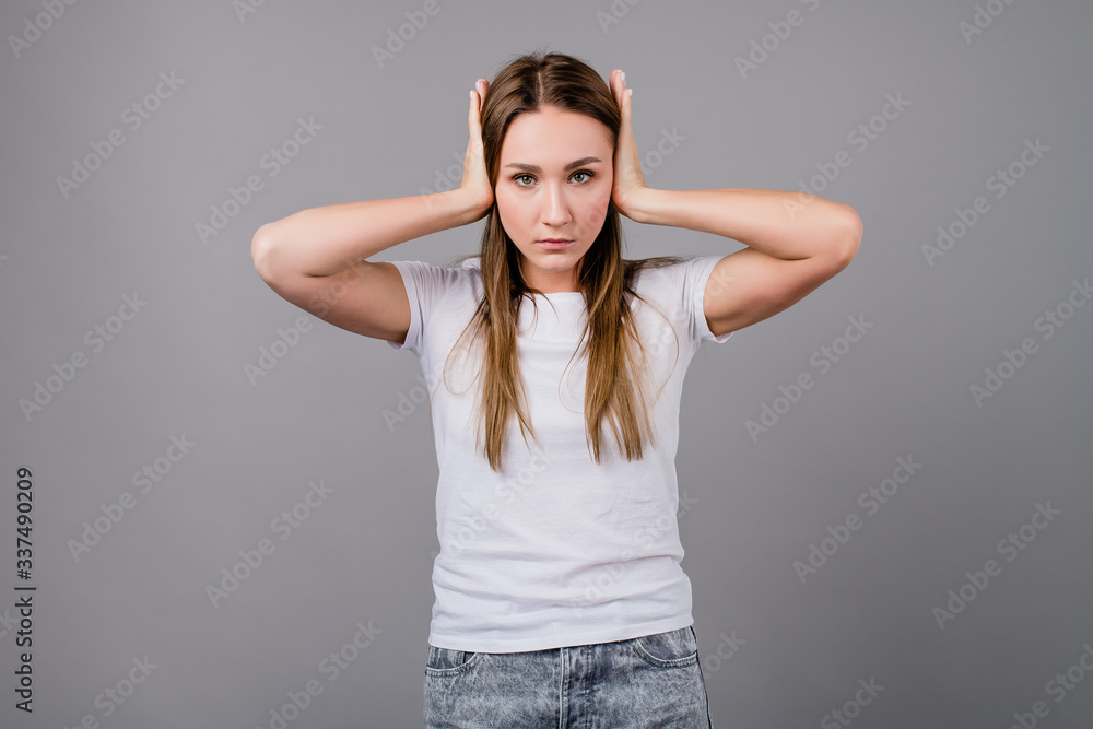 woman covering her ears isolated on grey background