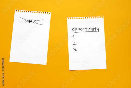 a sheet of paper with a crossed out word crisis and a sheet of paper with the inscription opportunity. concept of personal choice and new opportunities