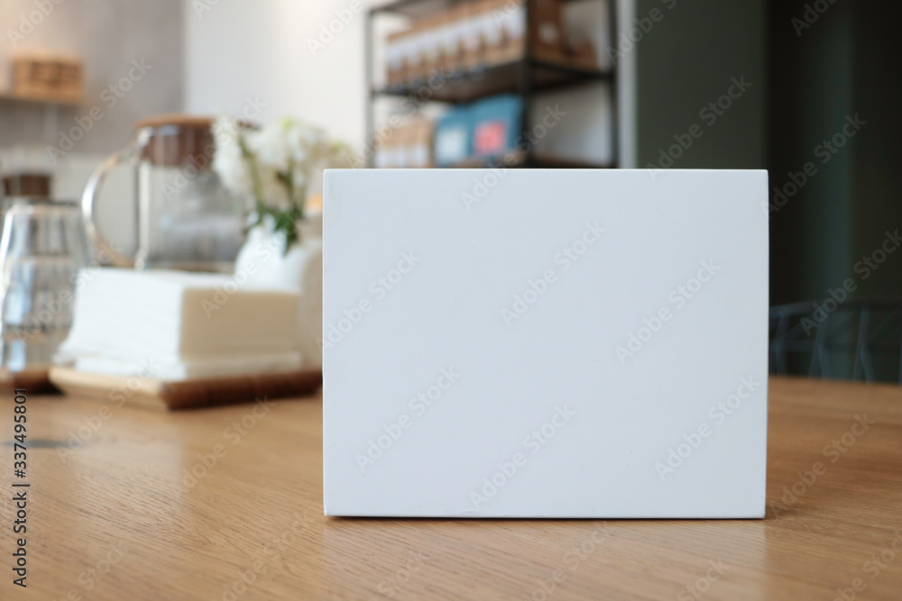 On the table is a white box suitable for mockup. Empty white background for design. White notebook. White paper. without text. Coffee house. Cafe background. notepad. Stylish modern photo On the table is a white box suitable for mockup. Empty white background for design. White notebook. White paper. without text. Coffee house. Cafe background. notepad. Stylish modern photo