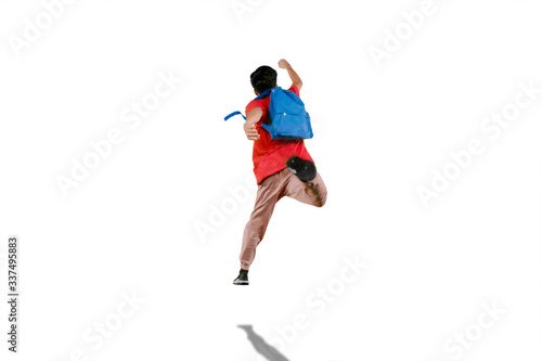 Male student jumping in the air with his backpack
