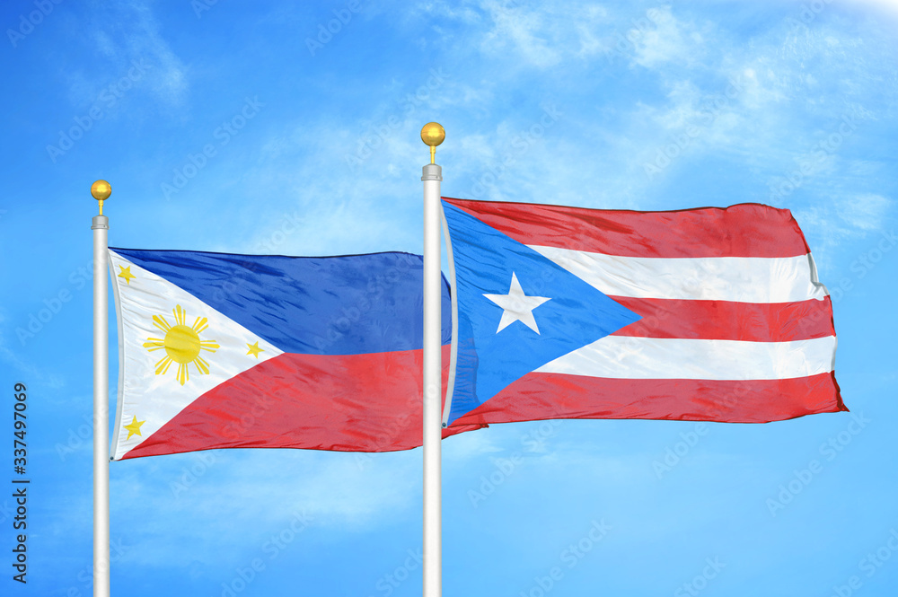 Philippines and Puerto Rico two flags on flagpoles and blue cloudy sky