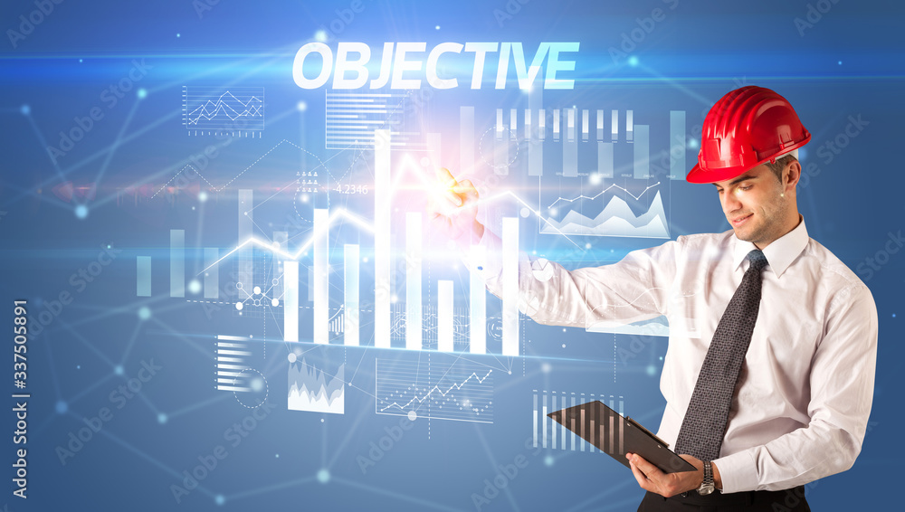 Handsome businessman with helmet drawing OBJECTIVE inscription, architecture business plan concept Handsome businessman with helmet drawing OBJECTIVE inscription, architecture business plan concept