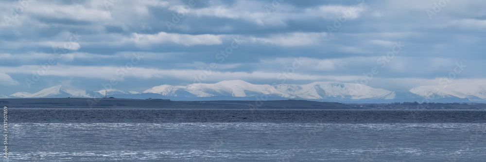 The Cairngorm Mountains in winter with snow on their peaks seen from Sutherland across the Moray Firth