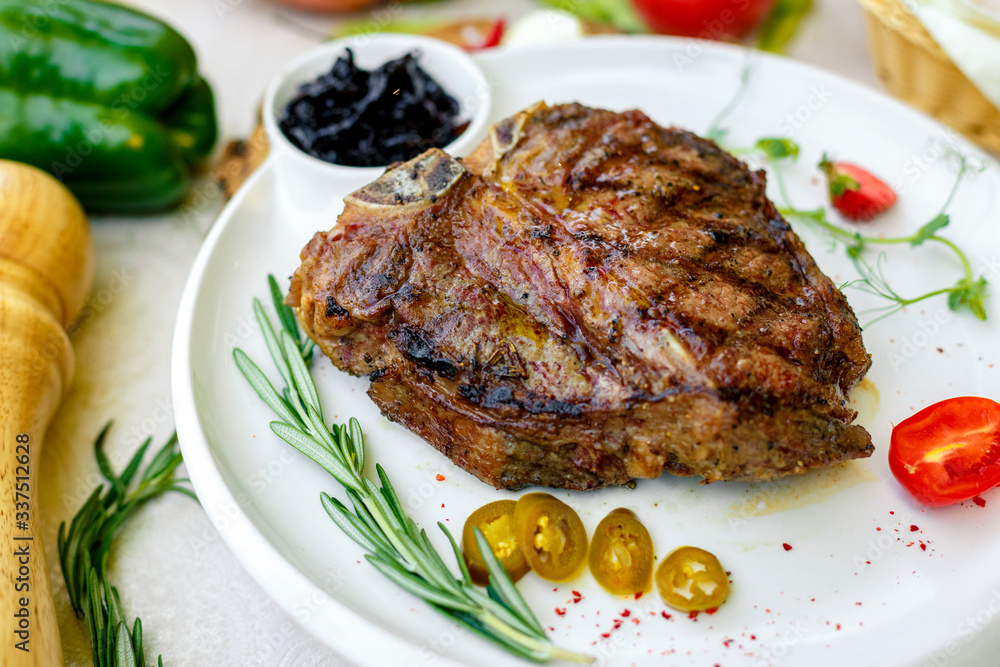 juicy barbecue steak with pickled onions and jalapeno on a white plate