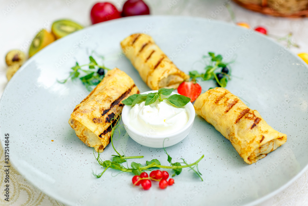 Pancakes with sour cream and berries on a decorated table for a holiday Pancakes with sour cream and berries on a decorated table for a holiday