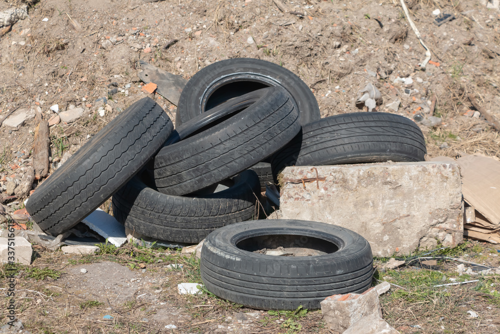 Old used tires lie near a pile of construction debris Old used tires lie near a pile of construction debris