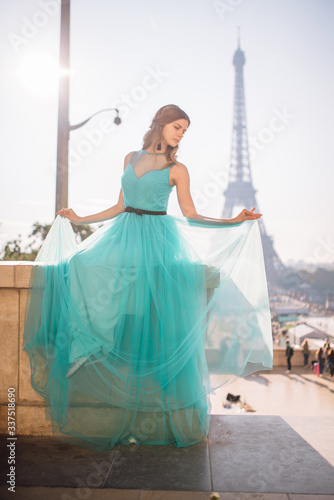 a girl in Paris in a green dress against the backdrop of the Eiffel tower elegant on the Trocadero square in summer a luxurious beautiful figure © Aleksei Zakharov