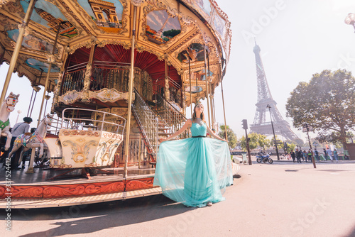 Beautiful young girl strolling through Paris next to the carousel  vintage atmosphere