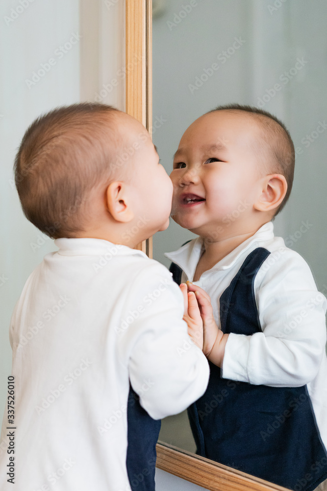 Baby playing in the bedroom in front of the mirror Baby playing in the bedroom in front of the mirror