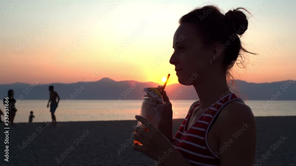 Carefree girl relaxing at the sea beach on amazing marine sunset ...