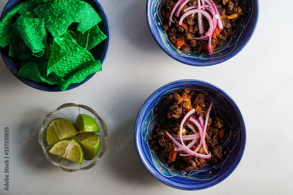 Fototapeta premium Black bean chili with condiments and chips