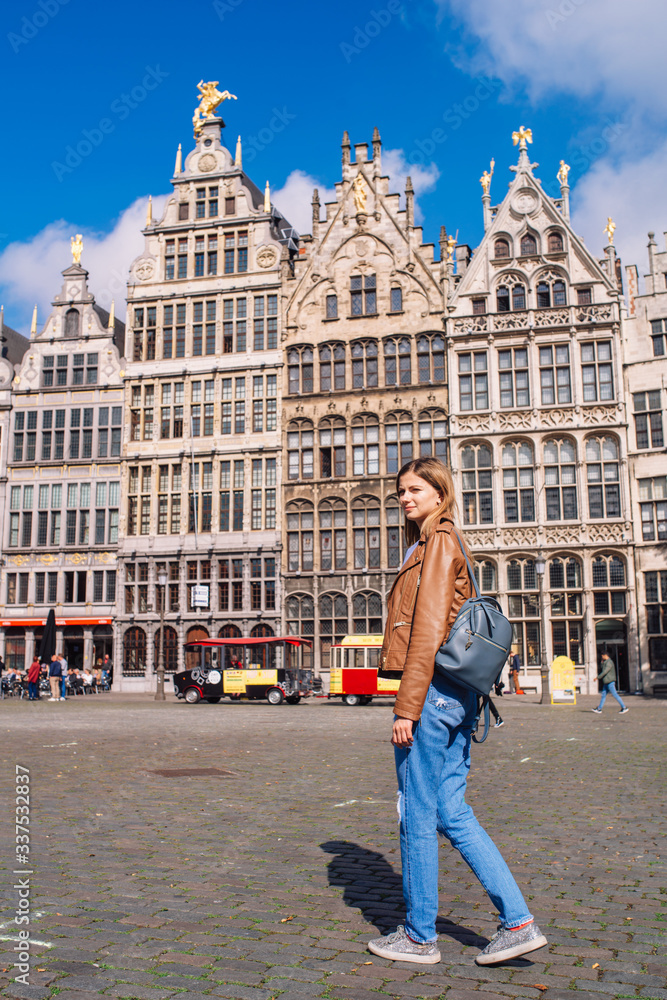 Obraz premium Young woman tourist walking on the Great Market square during the morning in Antwerpen