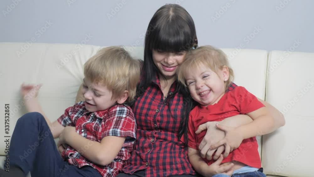 happy family little boy and girl laughs lifestyle from tickling mother. woman playing with son and daughter a happy family laughing indoors happy family little boy and girl laughs lifestyle from tickling mother. woman playing with son and daughter a happy family laughing indoors
