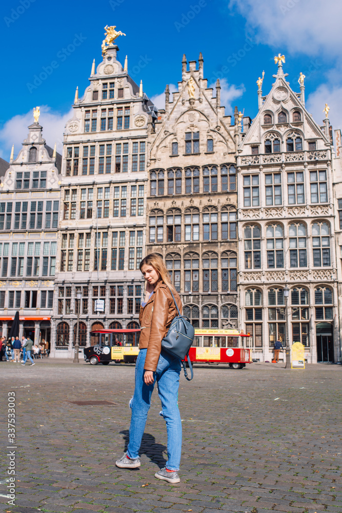 Young woman tourist walking on the Great Market square during the morning in Antwerpen
