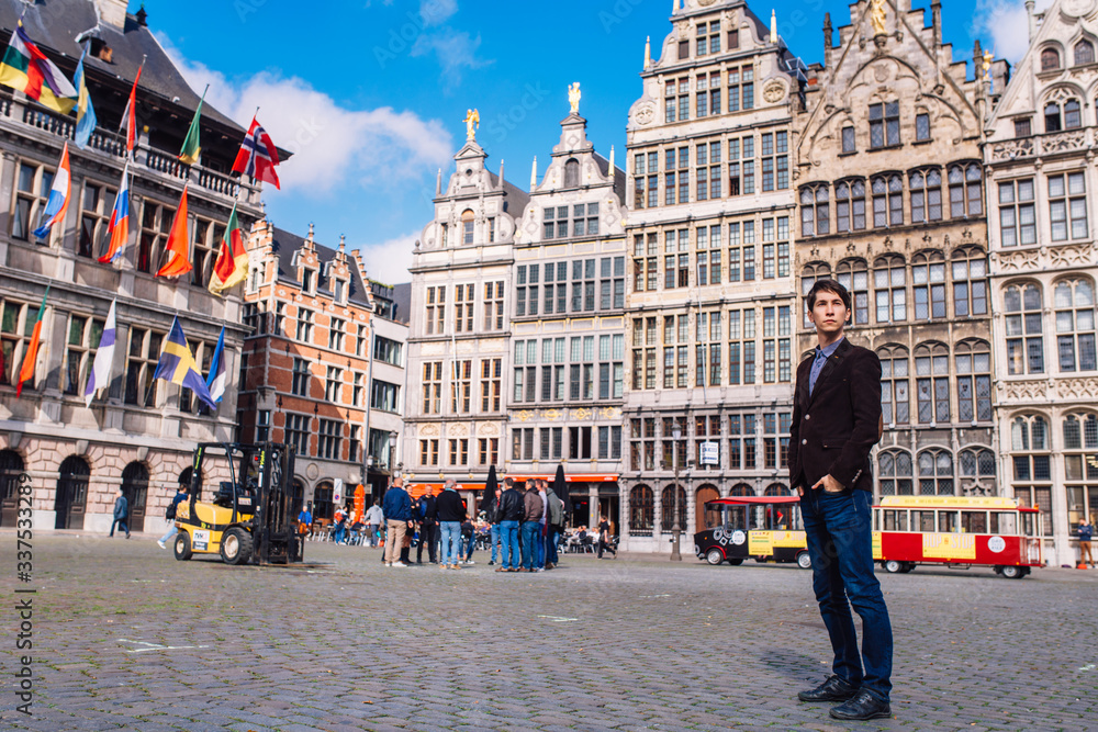 a man on Antwerp square with the city hall and Brabo monument in the Old city,