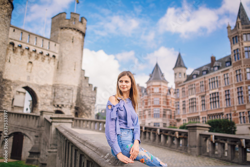 Young sexy girl with a beautiful face in a beautiful dress near the castle of Antwerp