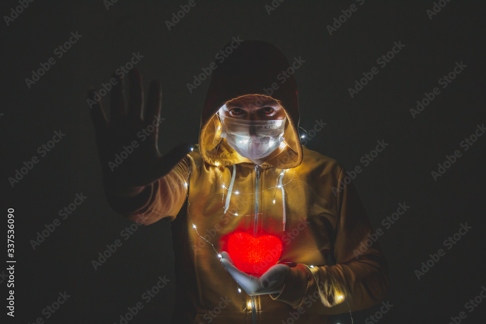 
man holding red heart in his hands in the dark