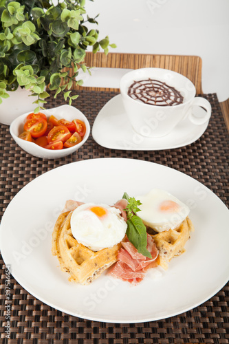 Healthy breakfast; tasty waffles with poached eggs.