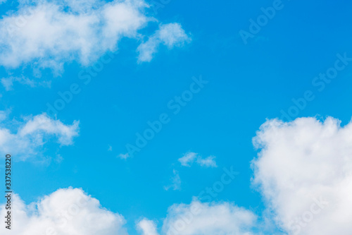 Bright clear blue sky with cumulus clouds. Space for text. Background.