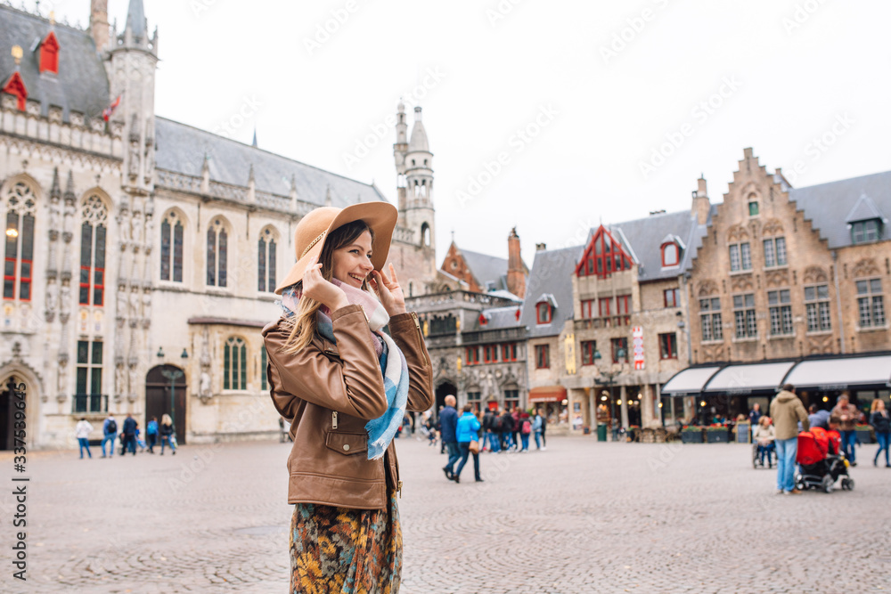 Fototapeta premium a girl looks at a historic building in Bruges