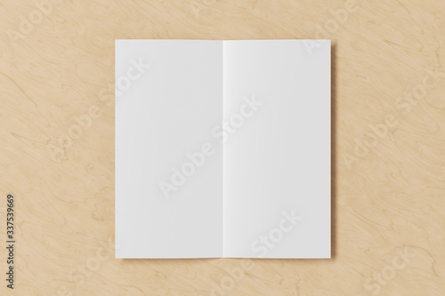 Blank square leaflet on wooden background. Bi-fold or half-fold opened brochure isolated with clipping path. View directly above. 3d illustration