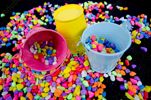 Tableau sur toile Colored buckets and beautiful river rocks