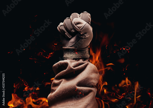Принти на полотні Hand fist in military glove on fire background.