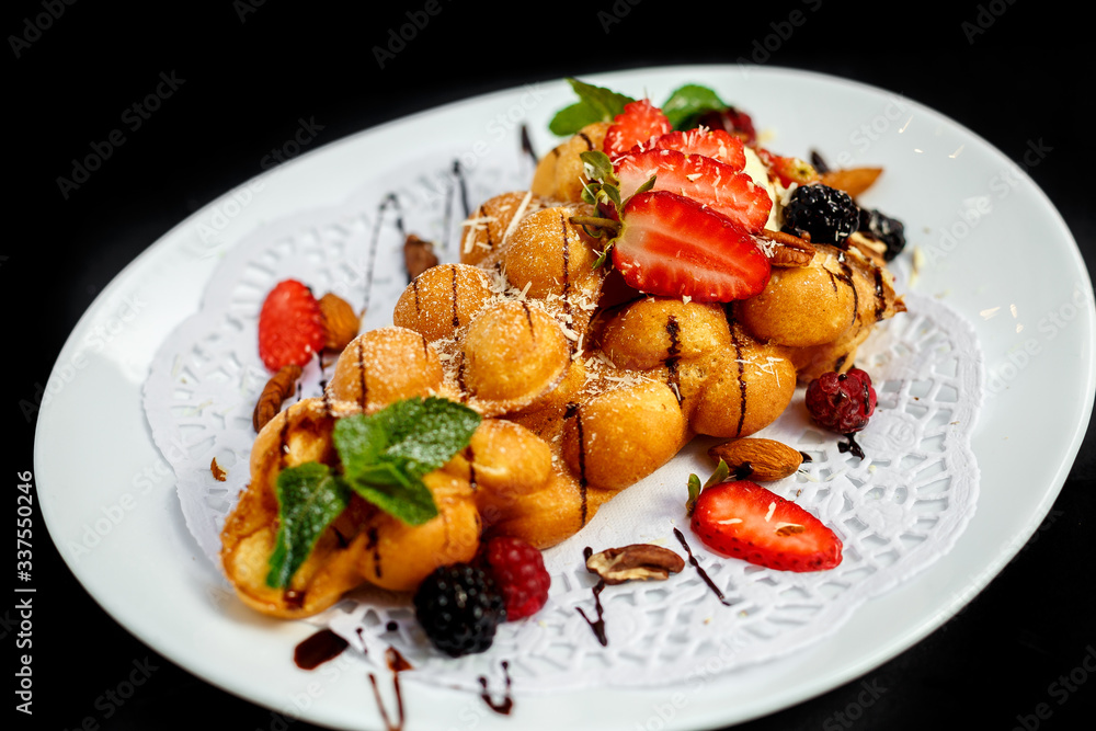 Waffles - a ball of Italian ice cream with berries and nuts and fresh fruit Waffles - a ball of Italian ice cream with berries and nuts and fresh fruit