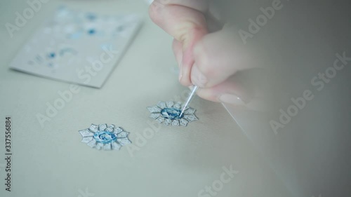 Young woman, a jewelry designer is drawing a sketch for a new ring at a jewelry