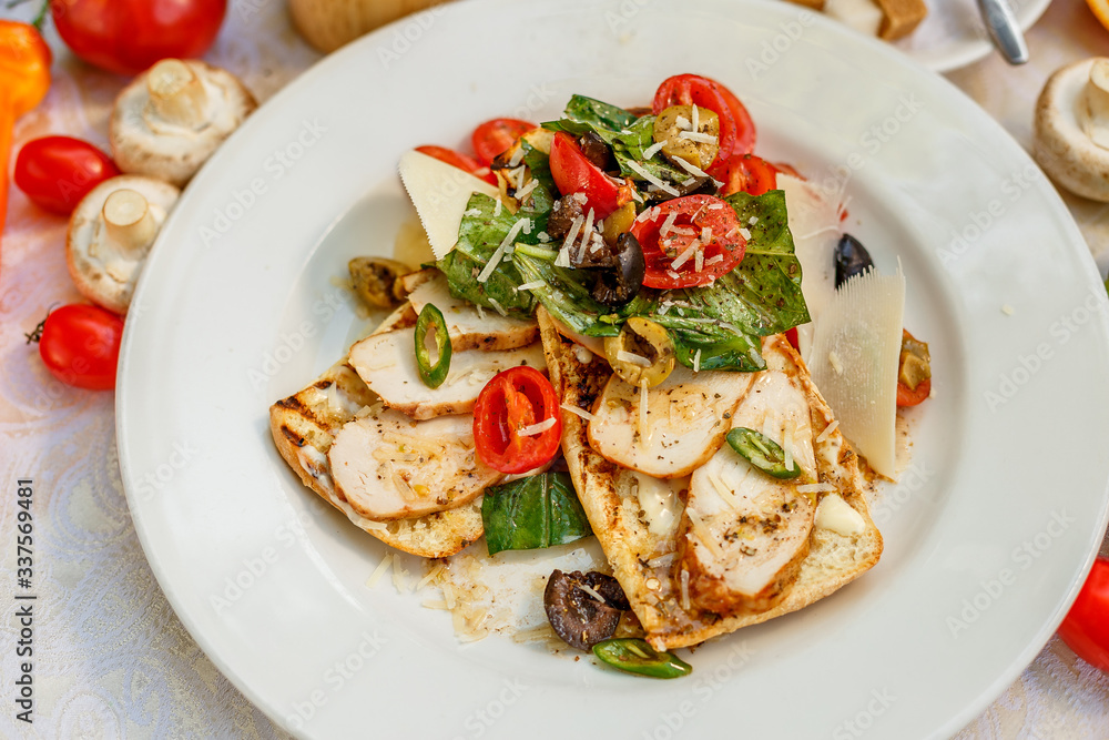 panini with chicken and vegetables on a plate on a decorated table panini with chicken and vegetables on a plate on a decorated table