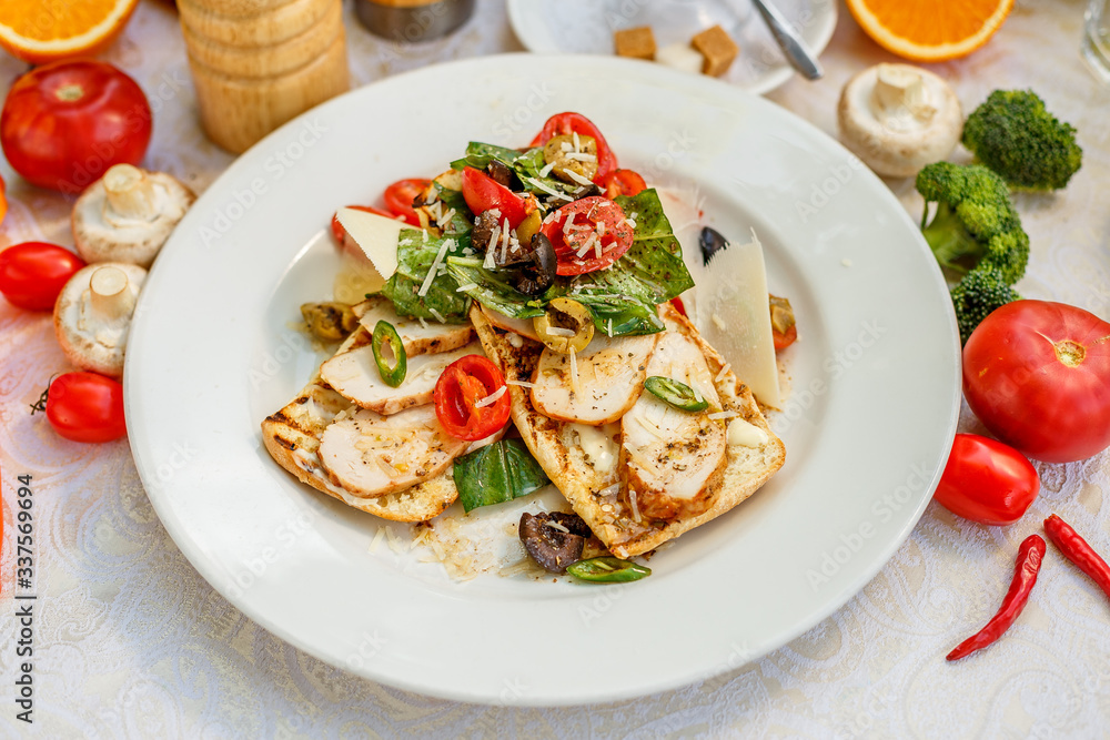 panini with chicken and vegetables on a plate on a decorated table panini with chicken and vegetables on a plate on a decorated table
