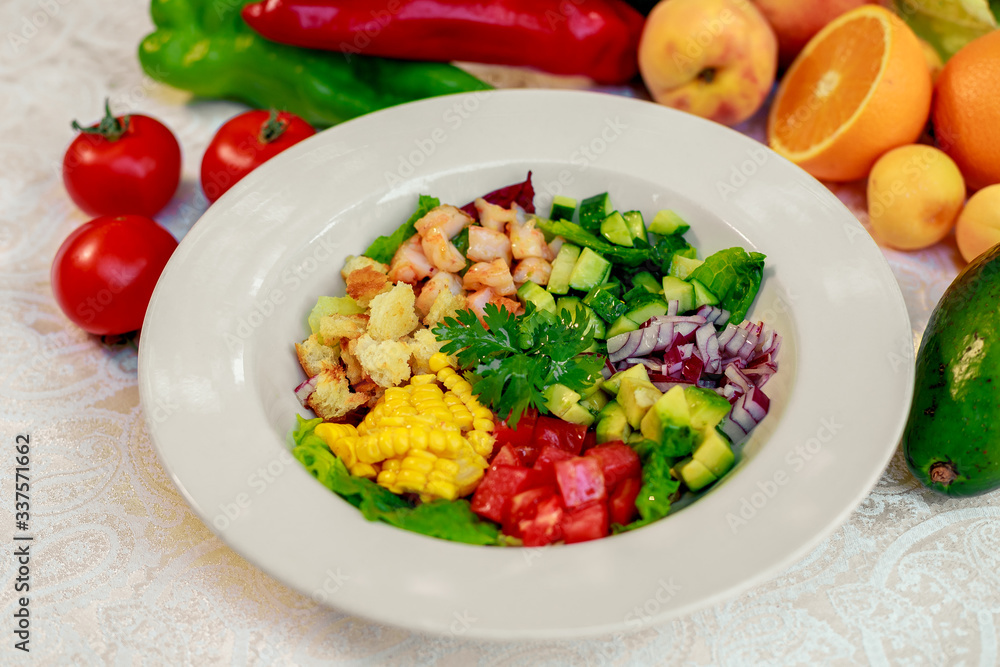 Healthy food, salad with shrimps, tomatoes, corn and avocado on a white table
