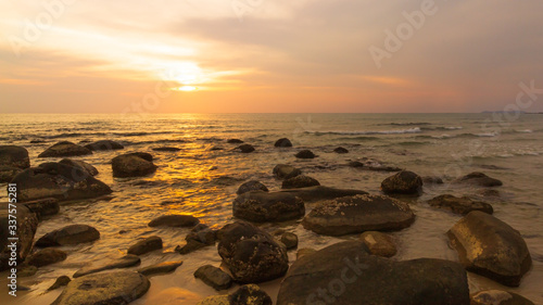 The beautiful orange sky with the rocks in the foreground