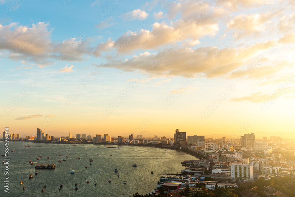 Pattaya city in the sunrise. The golden light of the sun shining on the right side.