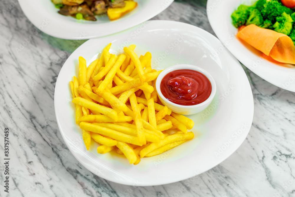 side dishes for the main course,potato fries with ketchup on a white plate, beautiful serve side dishes for the main course,potato fries with ketchup on a white plate, beautiful serve