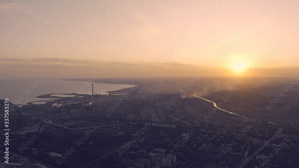 Industrial city in summer. On the horizon, a metallurgical plant near the sea. Aerial view. Mariupol, Ukraine