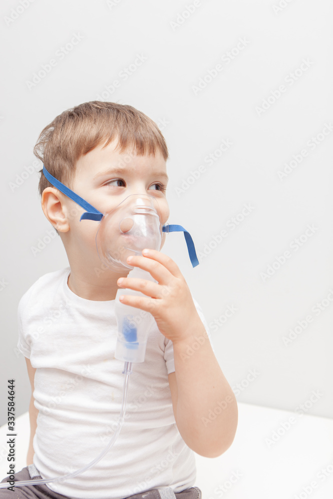 The boy makes inhalations. Treatment at home. Disease prevention The boy makes inhalations. Treatment at home. Disease prevention