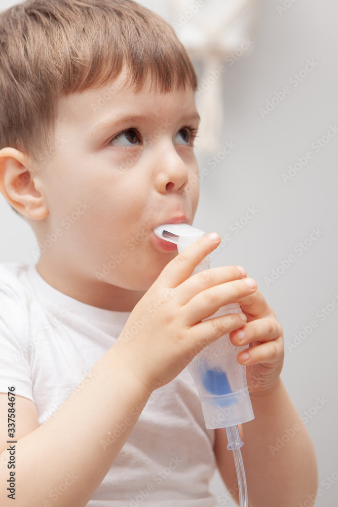 The boy makes inhalations. Treatment at home. Disease prevention The boy makes inhalations. Treatment at home. Disease prevention