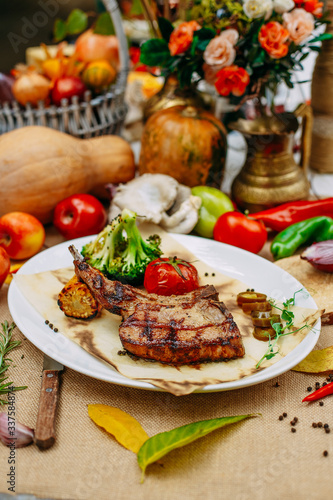 Autumn table setting with pumpkins. Thanksgiving dinner.Tomahawk Pork Steak with Vegetables