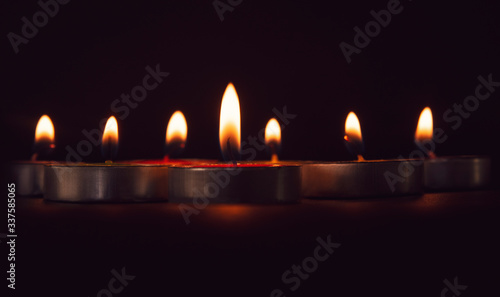 Group of colorful candles burning in the dark