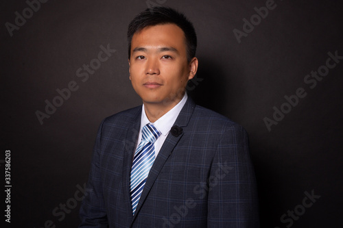 Chinese man in suit looking seriously, confidently at camera. Business portrait
