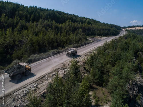 Huge industrial dumpers stone quarry transporting marble shot from drone chase