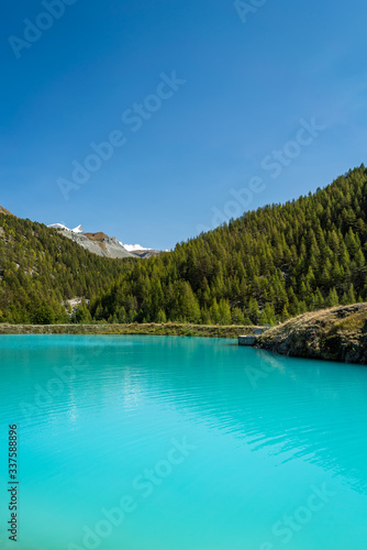 A scenic view of the beautiful Moosjisee lake with forest and mountains in the background in Zermatt, Switzerland