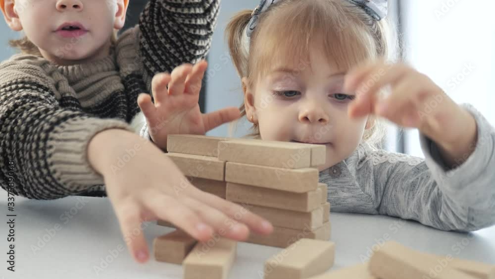 children play in designer wooden sticks teamwork. happy family kids little boy and girl lifestyle play in wooden blocks cubes build a house. brother and sister collect designer development of fine children play in designer wooden sticks teamwork. happy family kids little boy and girl lifestyle play in wooden blocks cubes build a house. brother and sister collect designer development of fine